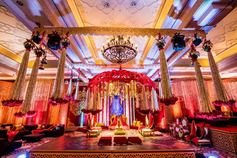 Reception stage with chandelier and floral backdrop