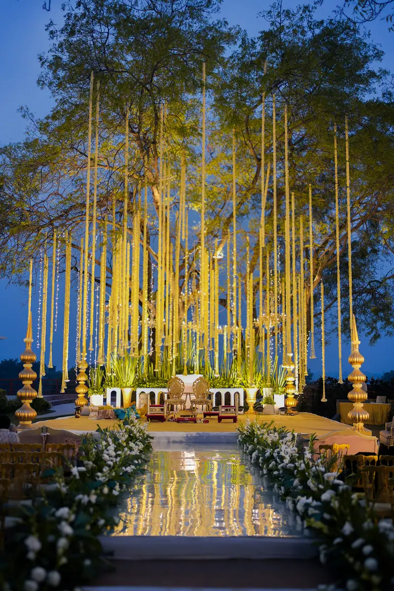 Hanging yellow flower strings over a lawn mandap